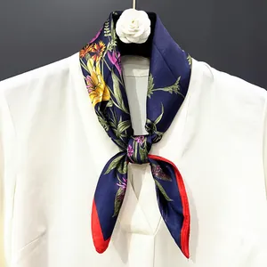 Detail of silk scarf with yellow lilies and purple butterflies tied on a white shirt