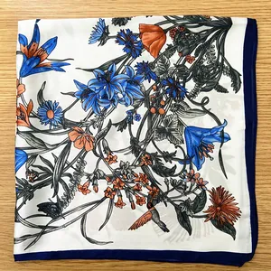 Detail of floral silk scarf featuring blue lilies and hummingbird on ivory background