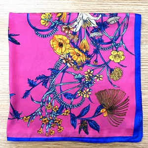 Close-up of fuchsia floral silk scarf with vibrant lily patterns and blue edge
