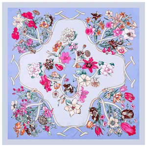 Elegant light blue silk-like square scarf with artistic floral patterns and ribbons