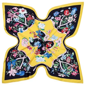 Detail of floral printed silk scarf with bright yellow base and navy blue border