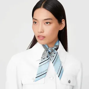 Detail of silk scarf with zebra print and dots tied on neck with white jacket