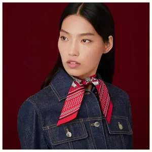 Close-up of deep red silk scarf with zebra pattern and polka dots on denim jacket
