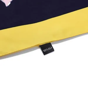 Detail of 100% silk floral scarf showing fabric texture and premium material label