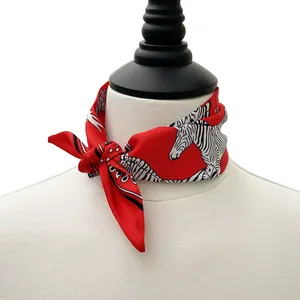 Detail of red silk scarf with zebra pattern elegantly tied on a white mannequin neck