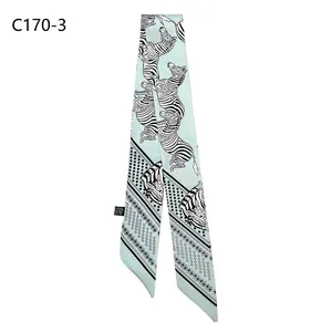 Close-up of zebra pattern green narrow scarf with polka dots and side material label