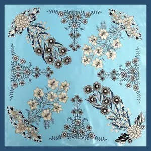 Detalle de un elegante pañuelo de seda cuadrado con estampado de lirios en base azul claro