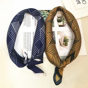 Close-up of navy and ginger geometric silk scarves elegantly knotted on a magazine backdrop