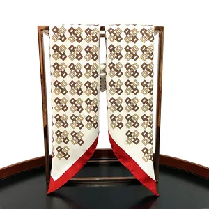 Detail of hand-rolled edges on silk scarf featuring geometric lattice patterns on a metal rack