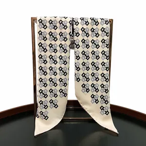 Close-up of geometric pattern on 90cm twill silk scarf displayed on a bronze stand