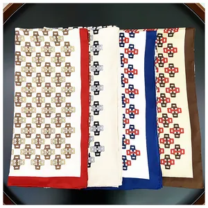 Detail view of four silk square scarves with geometric chain patterns in a display tray