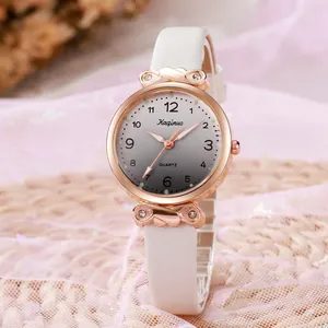 Détail d'une montre à quartz rose doré avec cadran dégradé gris et bracelet en cuir blanc
