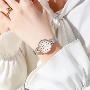 Elegant rose gold women's watch with silver mesh band and white dial on wrist