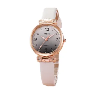 Montre quartz pour femme à la mode avec boîtier en or rose et bracelet en cuir rose sur fond blanc