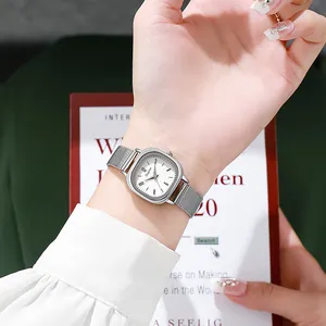 Minimalist women's silver square quartz watch with a stainless steel mesh strap on wrist
