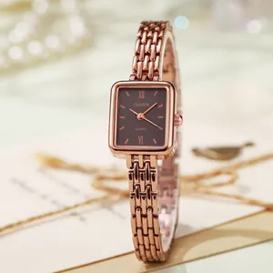 Dettaglio di un orologio vintage rettangolare in oro rosa con quadrante marrone e maglia