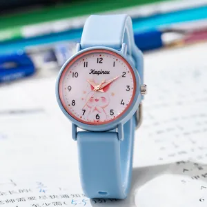 Gros plan d'une montre enfant bleu clair avec cadran lapin sur fond de bureau scolaire