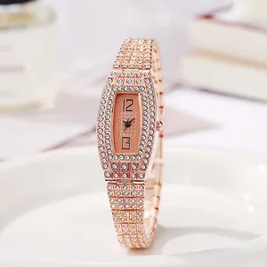 Gros plan d'une montre tonneau élégante en or rose avec strass sur une assiette blanche