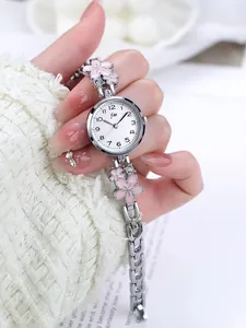 Macro shot of a silver watch band featuring pink enamel cherry blossom and crystal accents