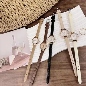 Detailed close-up of five colorful quartz watches with slim leather straps on a tray