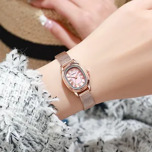 Women's rose gold oval mesh watch with pink sunray dial shown on a female wrist