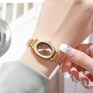 Makroaufnahme der goldenen ovalen Uhr mit braunem Zifferblatt und elegantem Metallarmband