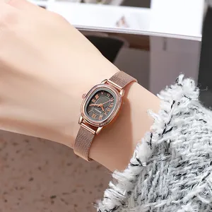 Close-up of rose gold oval watch with Milanese mesh strap and Roman numeral dial