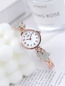 Macro view of rose gold floral watch strap with green enamel and white crystals