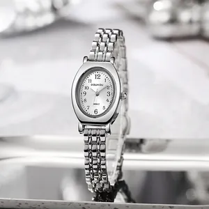 Details der silbernen ovalen Uhr mit weißem Zifferblatt und poliertem Gliederarmband