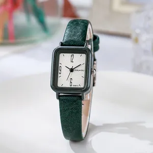 Détail du bracelet en cuir vert et du cadran rectangulaire d'une montre à quartz femme