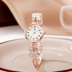 Detailed macro view of elegant rose gold watch with white floral strap ornaments and crystal