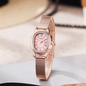 Detail of rose gold oval watch with pink dial and vintage Roman numerals on mesh strap