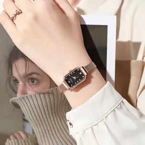 Elegant rose gold rectangular watch with mesh strap and floral ring on model wrist
