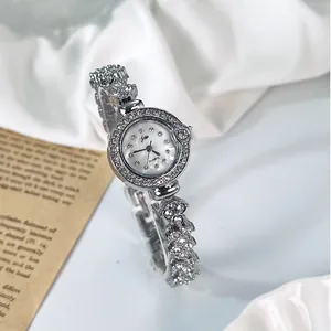 Gros plan détaillé d'une montre bracelet à quartz argentée ornée de cristaux sur le cadran
