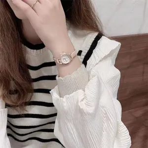 Close-up of ULZZANG thin beige leather strap watch with rose gold case on woman wrist