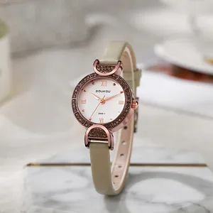 Detail der roségoldenen Uhr mit kristallbesetzter Lünette und beige Lederarmband