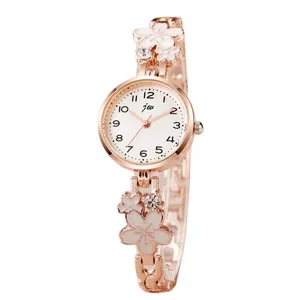 Elegant rose gold women's watch with white enamel floral strap and crystal accents