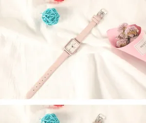 Gros plan d'une montre rectangulaire minimaliste pour femme avec bracelet en cuir beige