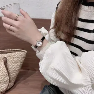 Close-up of elegant small dial women's watch with black leather strap and rose gold case