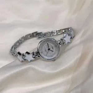 Detailed macro view of the silver star link strap and heart-patterned dial on women watch
