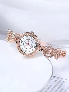 Details einer roségoldenen Damenuhr mit funkelnden Strasssteinen und Wirbelarmband