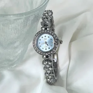 Détail d'une montre argentée pour femme avec lunette strass et bracelet élégant
