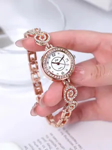 Detailaufnahme einer roségoldenen Schmuckuhr mit kristallbesetztem Spiralarmband