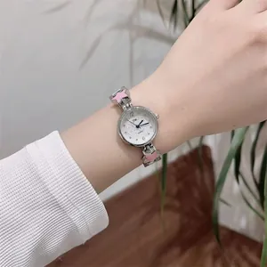 Detailed close-up of a silver watch with pink star motifs and heart pattern dial