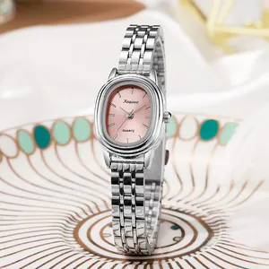 Detail van zilveren stalen horloge met ovale roze wijzerplaat op keramisch bord