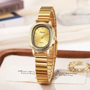 Detail van elegant gouden ovaal quartzhorloge met geborstelde wijzerplaat op hout
