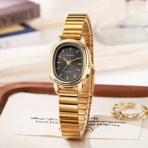 Detail van een elegant goud ovaal horloge met zwarte wijzerplaat op houten dienblad