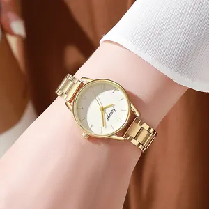 Montre à quartz dorée élégante avec bracelet en acier et cadran blanc au poignet féminin