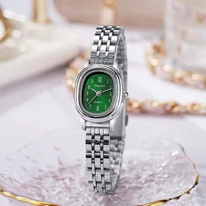 Dettaglio macro del quadrante ovale verde e del cinturino in argento di questo orologio