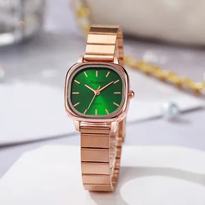 Detail of rose gold square watch with a deep green sunray dial and bamboo link band